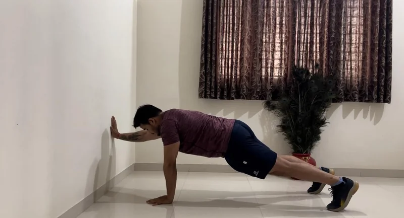 Man doing wall push-ups at home
