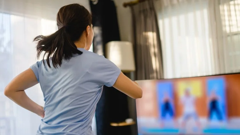 Member following a Zumba class on her TV at home